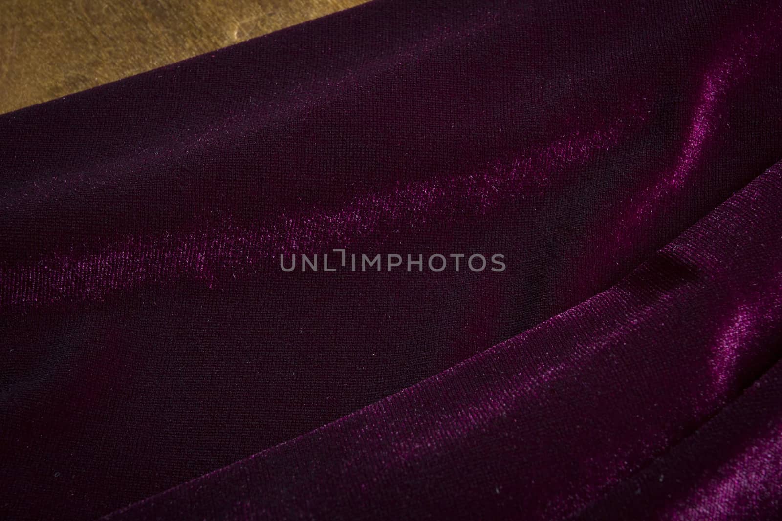 Purple velor fabric on a wooden surface