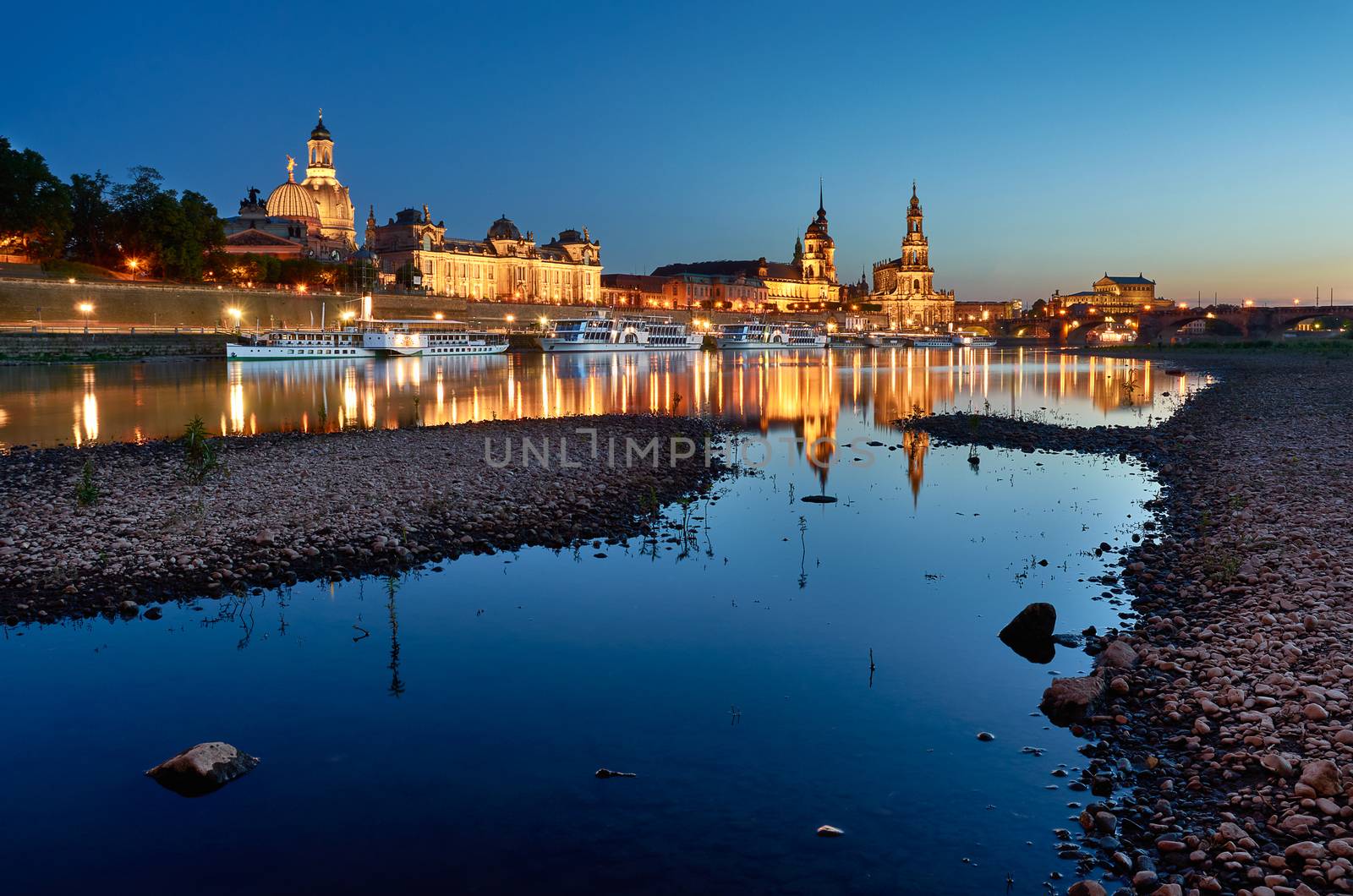 Dresden city skyline in blue hour from the river with rocks