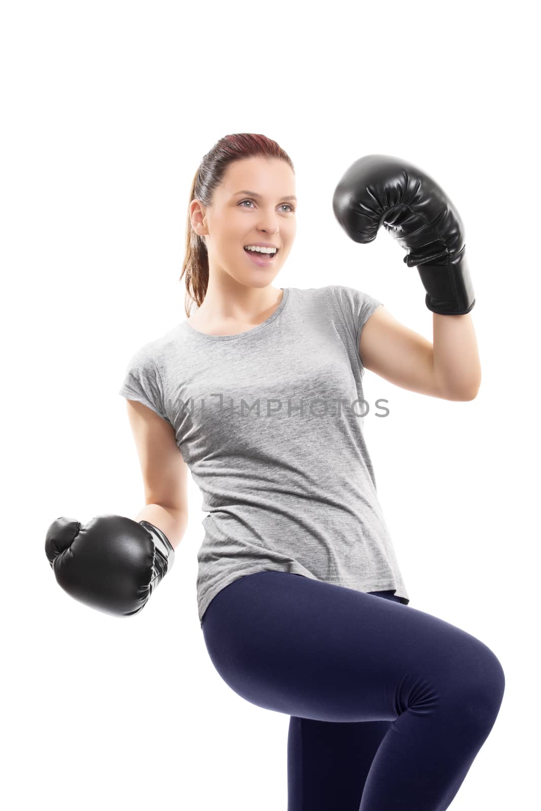 A portrait of a young beautiful girl with boxing gloves cheering and celebrating her success, isolated on white background.