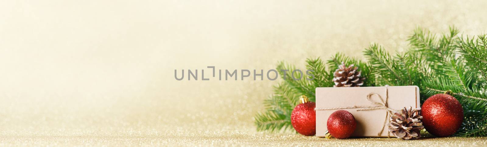 Christmas toys, decorations, present gift box wrapped in kraft paper on golden glitter background, copy space