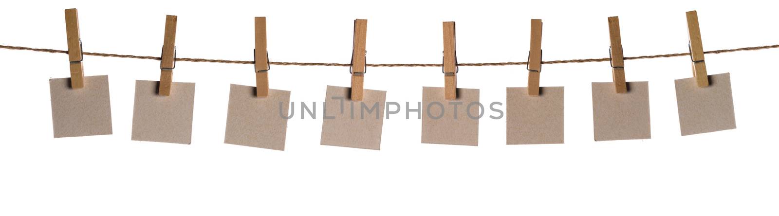Set of eight blank paper notes held on a string with clothespins isolated on white background