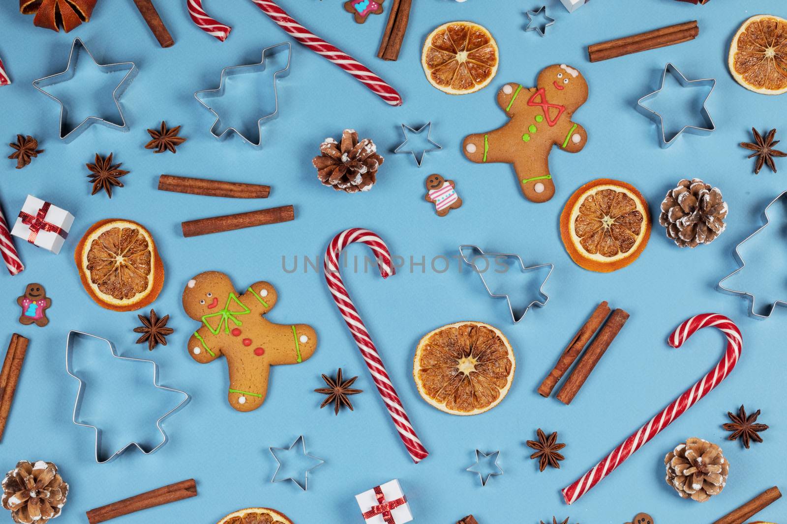Christmas food frame. Gingerbread cookies, spices and decorations on blue background with copy space