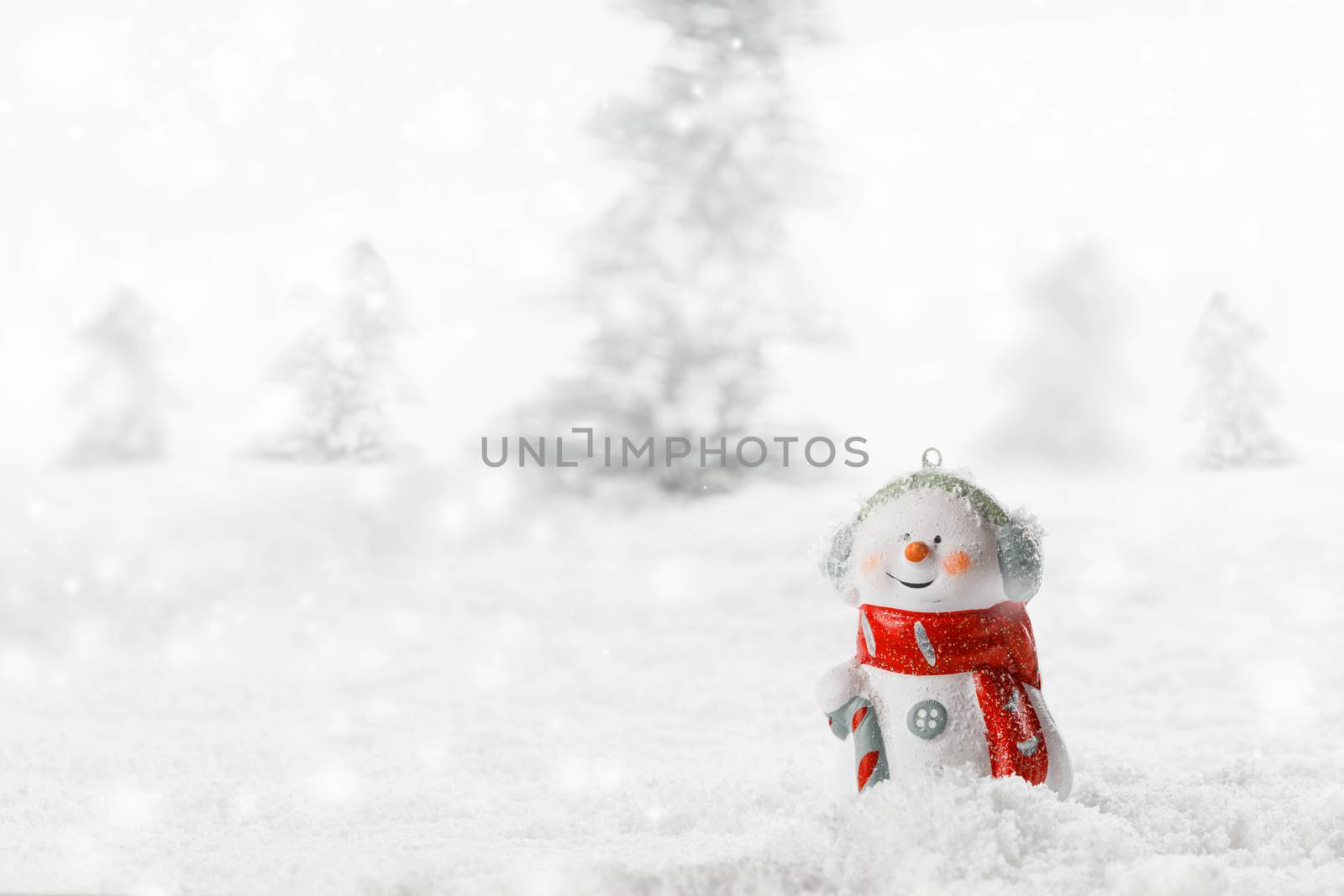Christmas Snowman toy on winter forest background in the snow