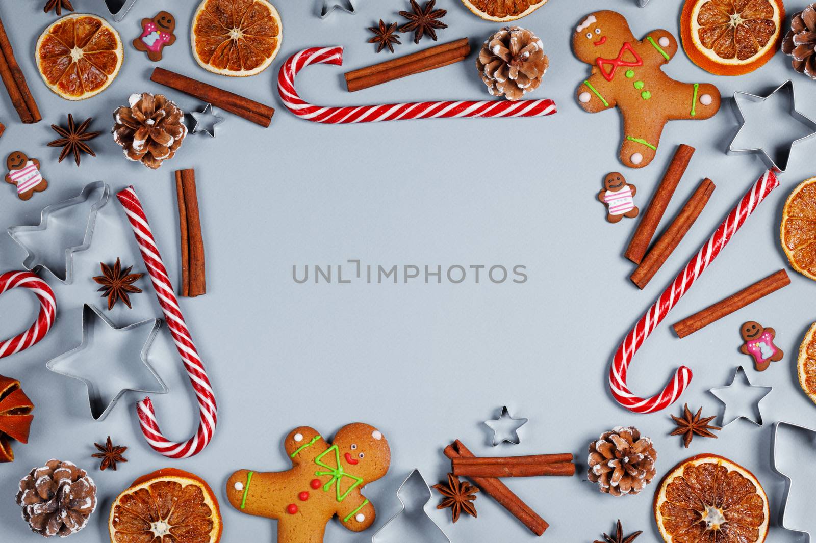 Christmas food frame. Gingerbread cookies, spices and decorations on blue background with copy space