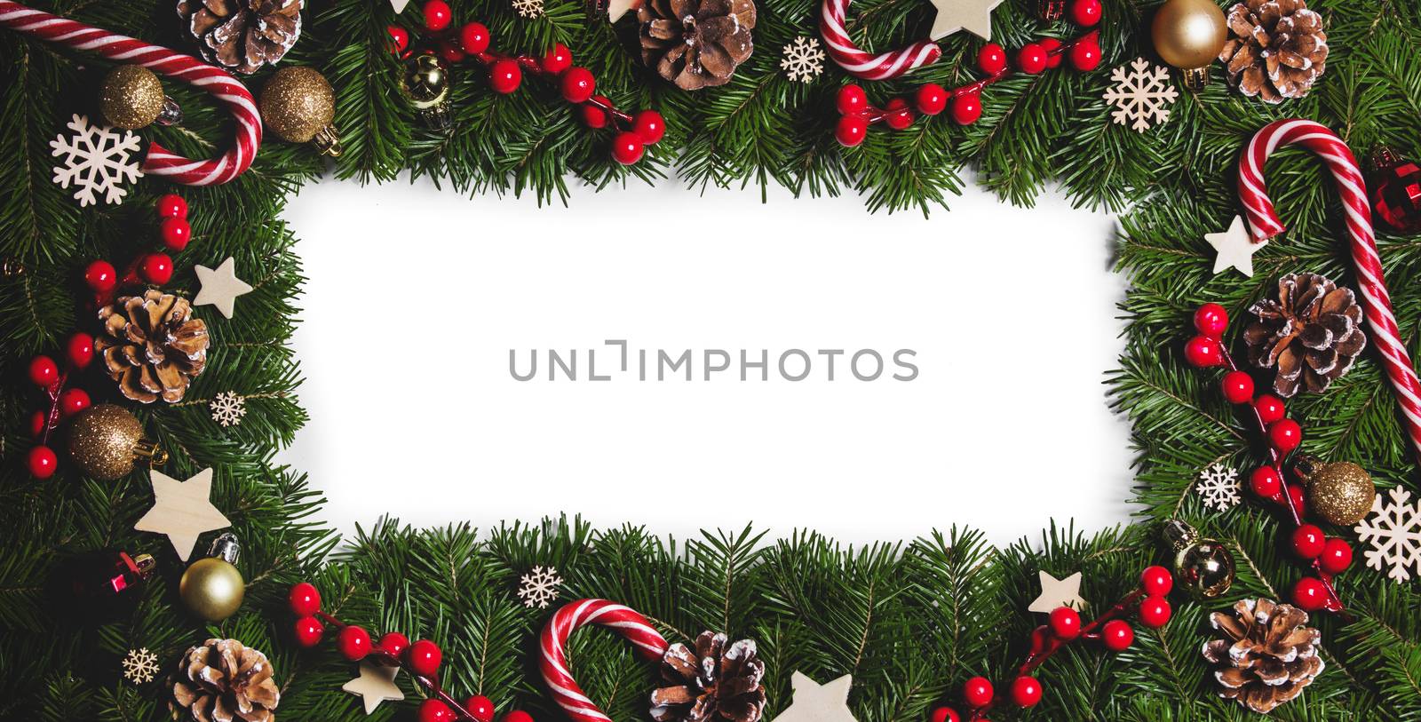 Christmas Border frame of tree branches on white background with copy space isolated, red and white decor, berries, stars, cones
