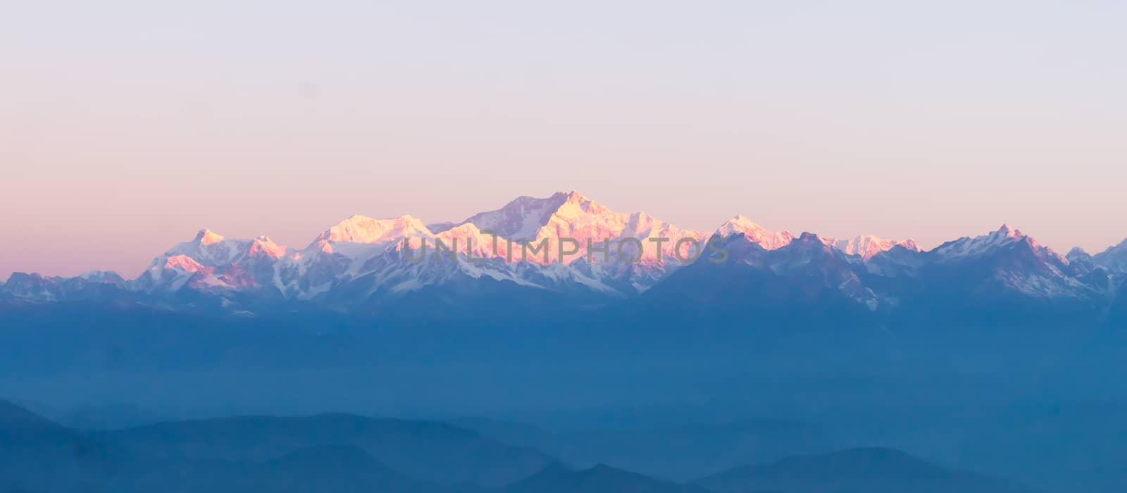 Panorama of majestic Mount Kanchendzonga range of himalayas at first sunrise from Tiger Hill. First ray of sun struck mountain starting beautiful day on entire nature around. Darjeeling, Sikkim, India