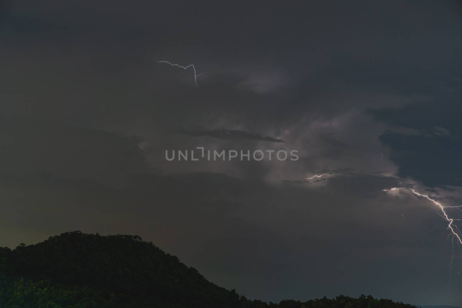 The Storm lightning strikes in mountains during a thunderstorm at night. Beautiful dramatic view