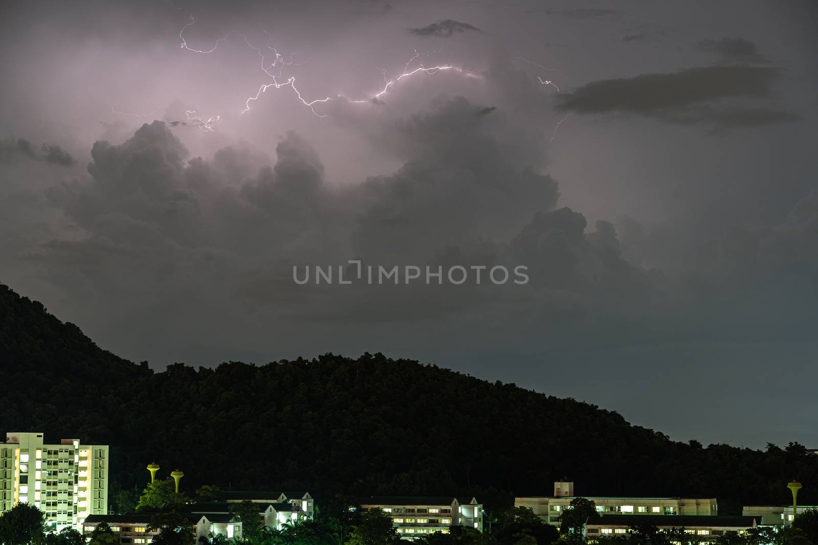 Storm lightning strikes in mountains during a thunderstorm at night. Beautiful dramatic view by peerapixs