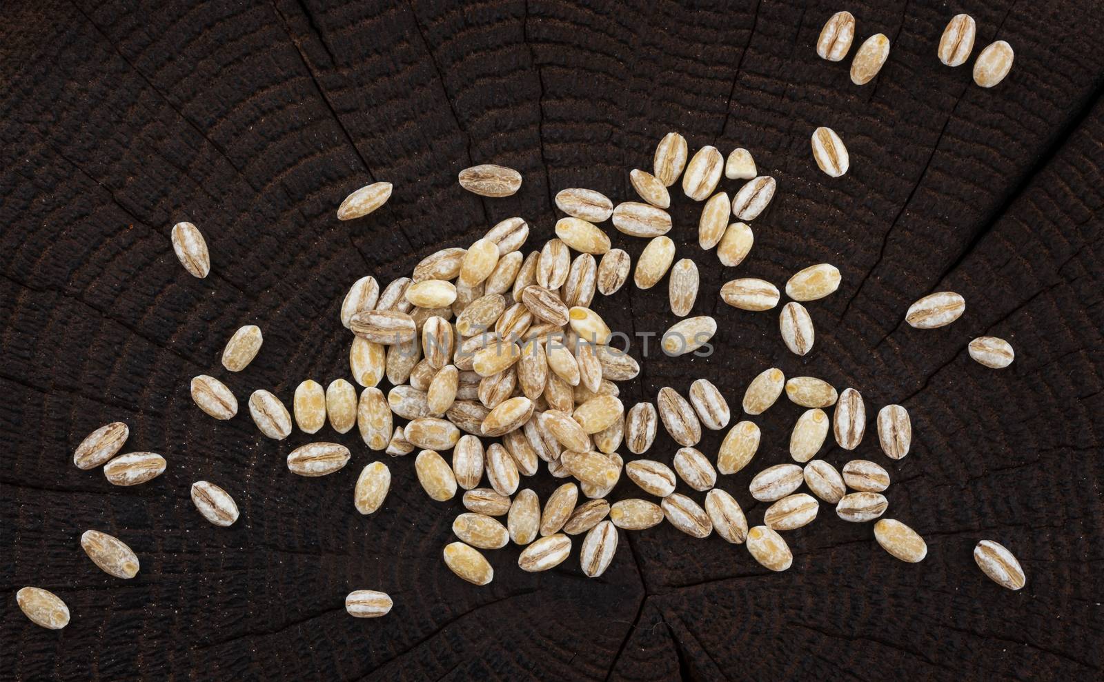 Heap of pearl barley on black wooden background. Top view by xamtiw