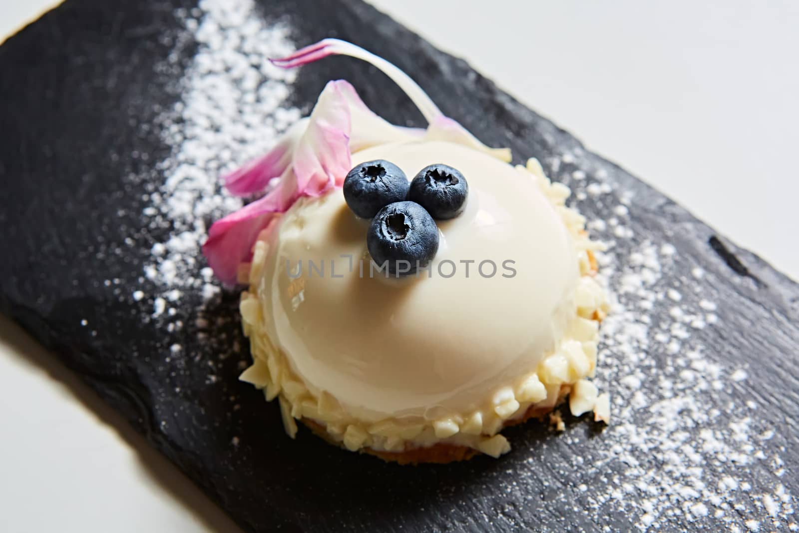 Vanilla bavarian mousse cake with cherries and dark chocolate on top. Made with cream cheese and whipped cream.