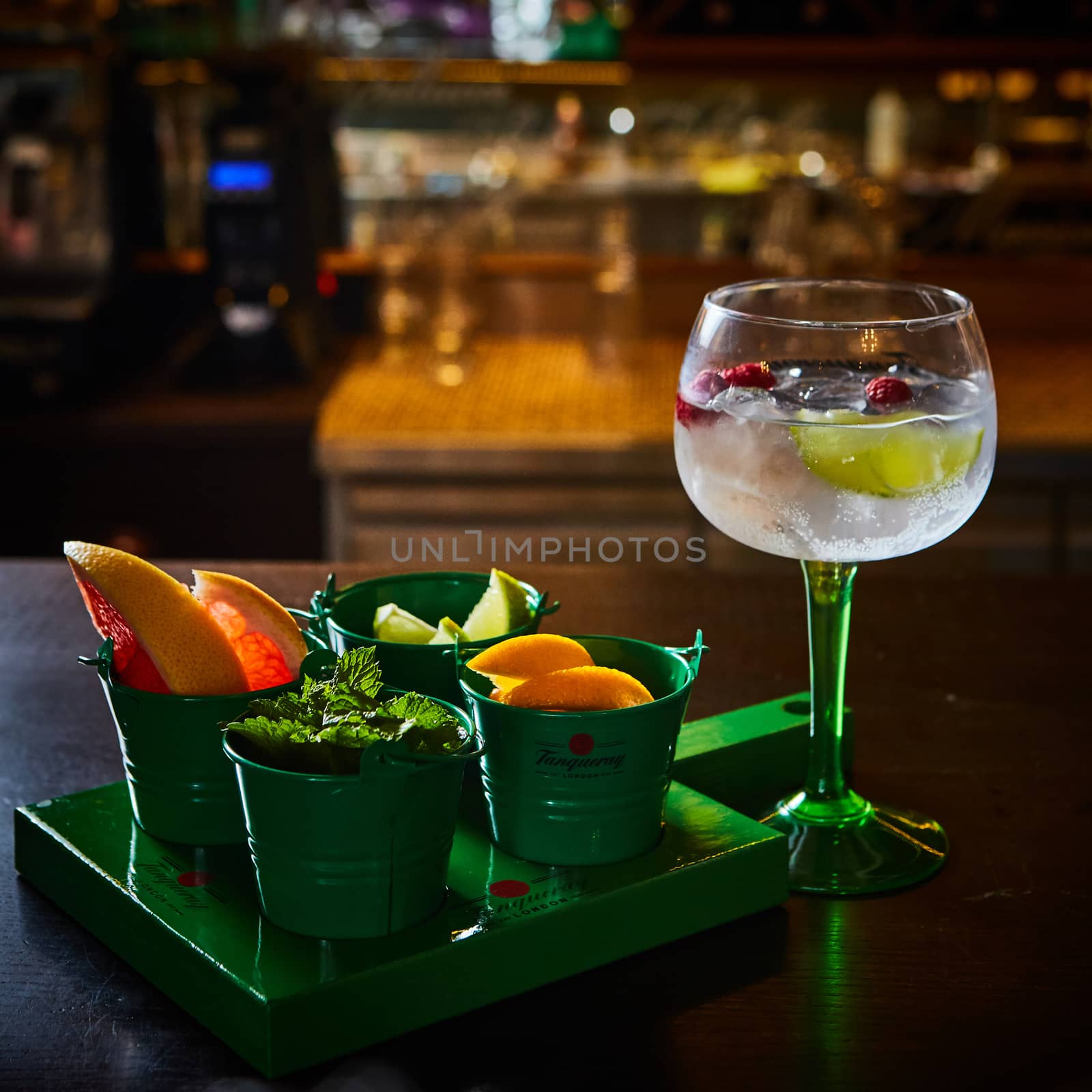 Raspberry Mojito Lemonade with lime and fresh mint in glass on wooden background. by sarymsakov