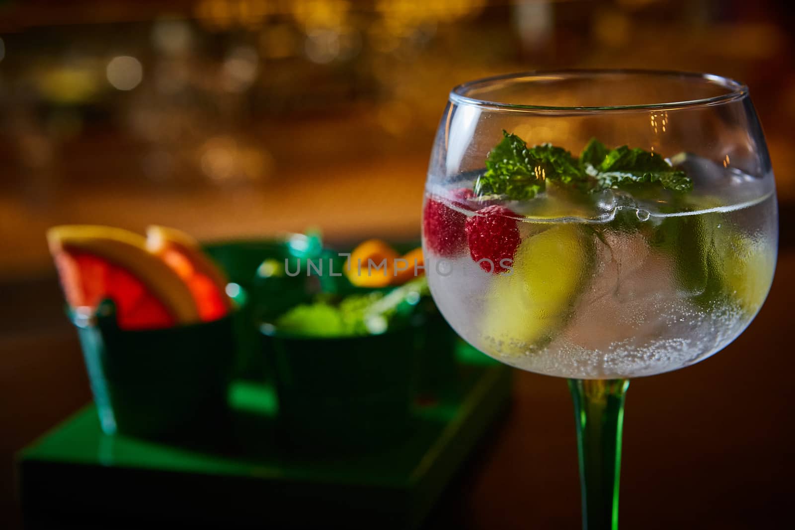 Raspberry Mojito Lemonade with lime and fresh mint in glass on wooden background. Summer refreshing cocktail
