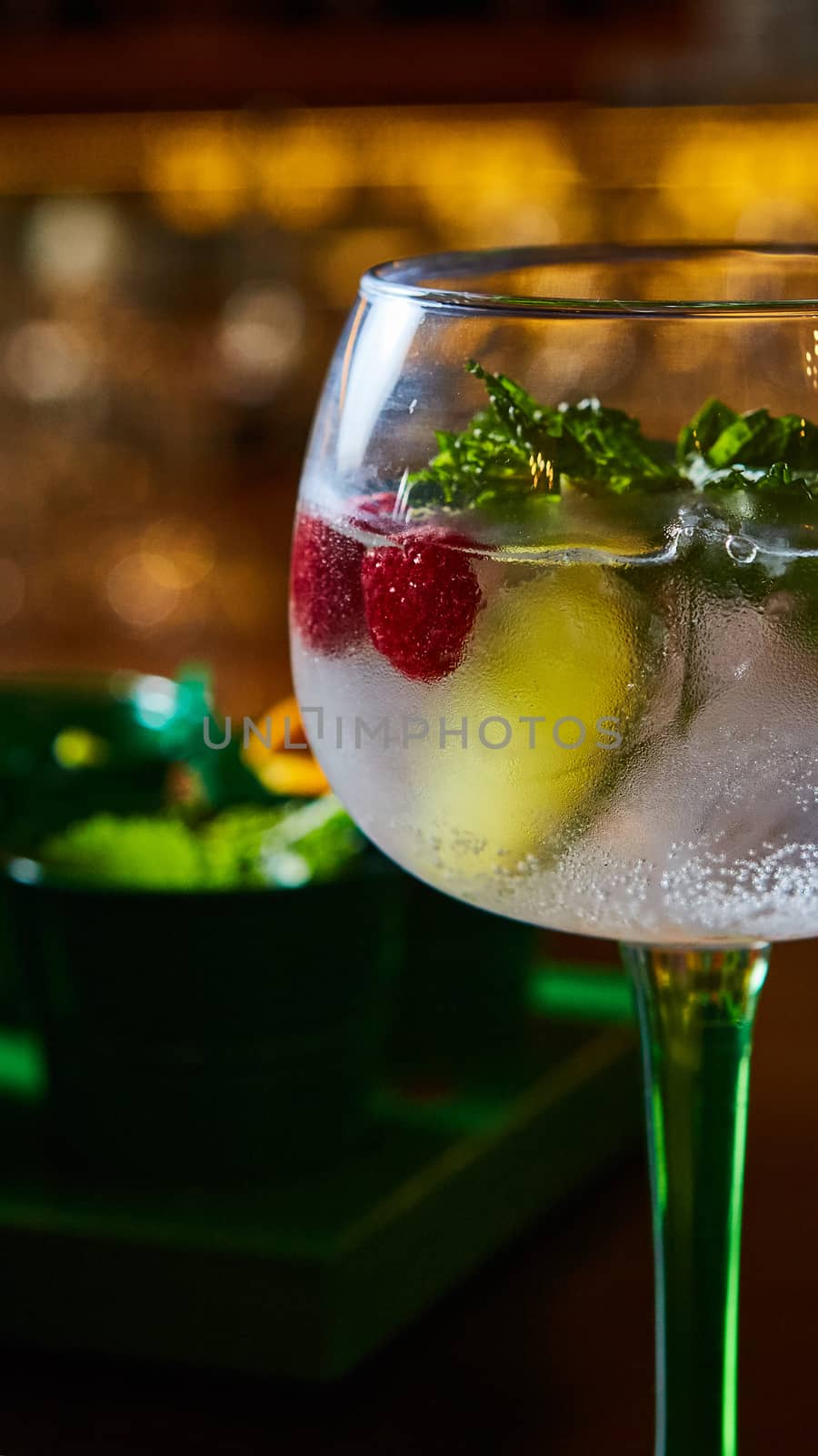 Raspberry Mojito Lemonade with lime and fresh mint in glass on wooden background. Summer refreshing cocktail