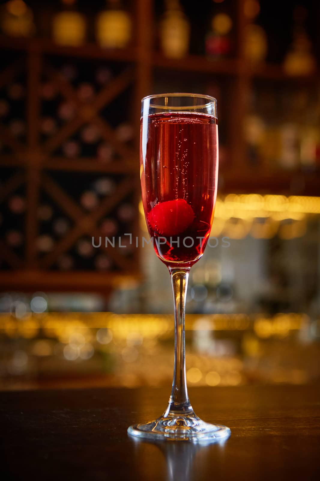 Red Cocktail in Champagne Glass near in the Bar with Amazing Blurred Background