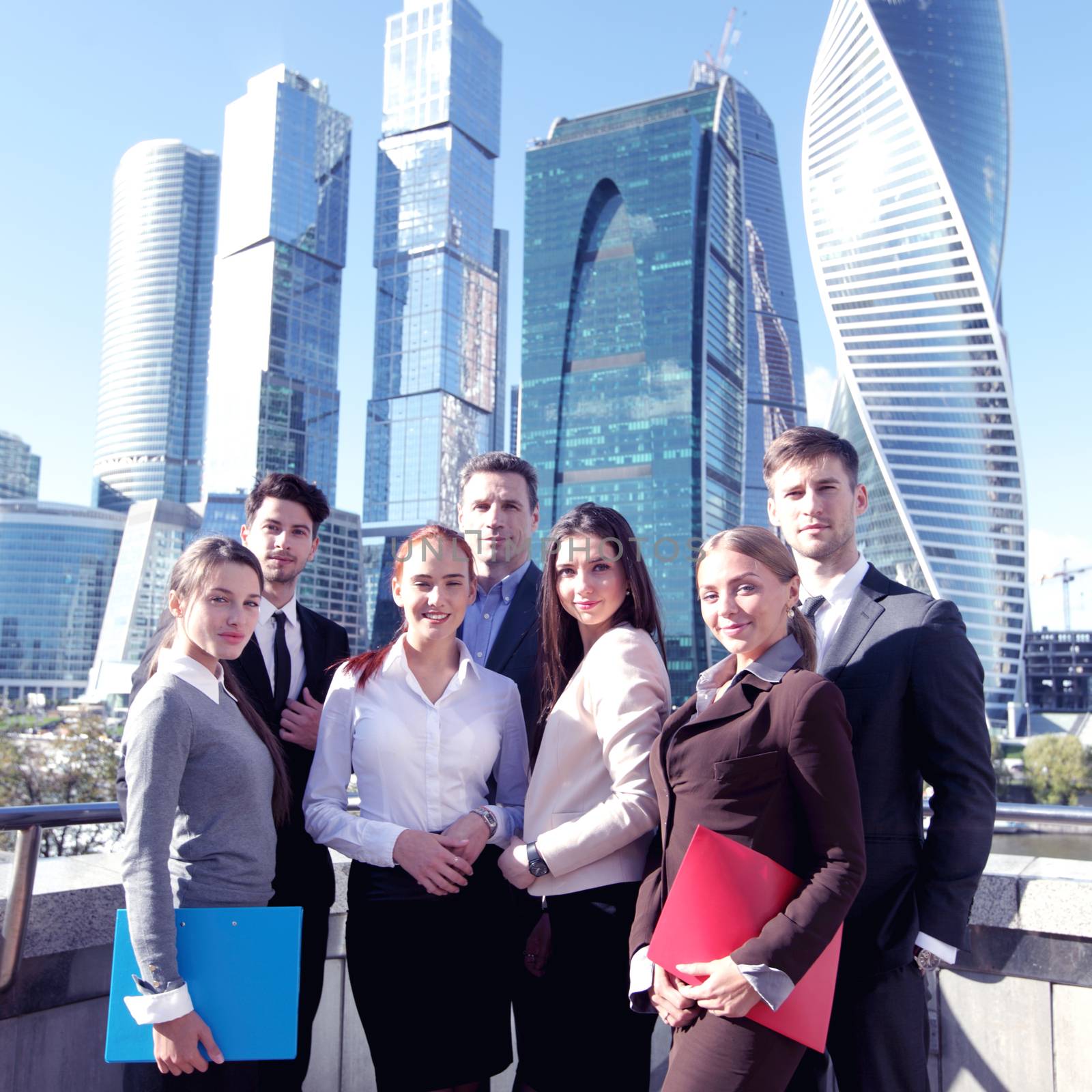 Portrait of business team outside office on skyscrapers background