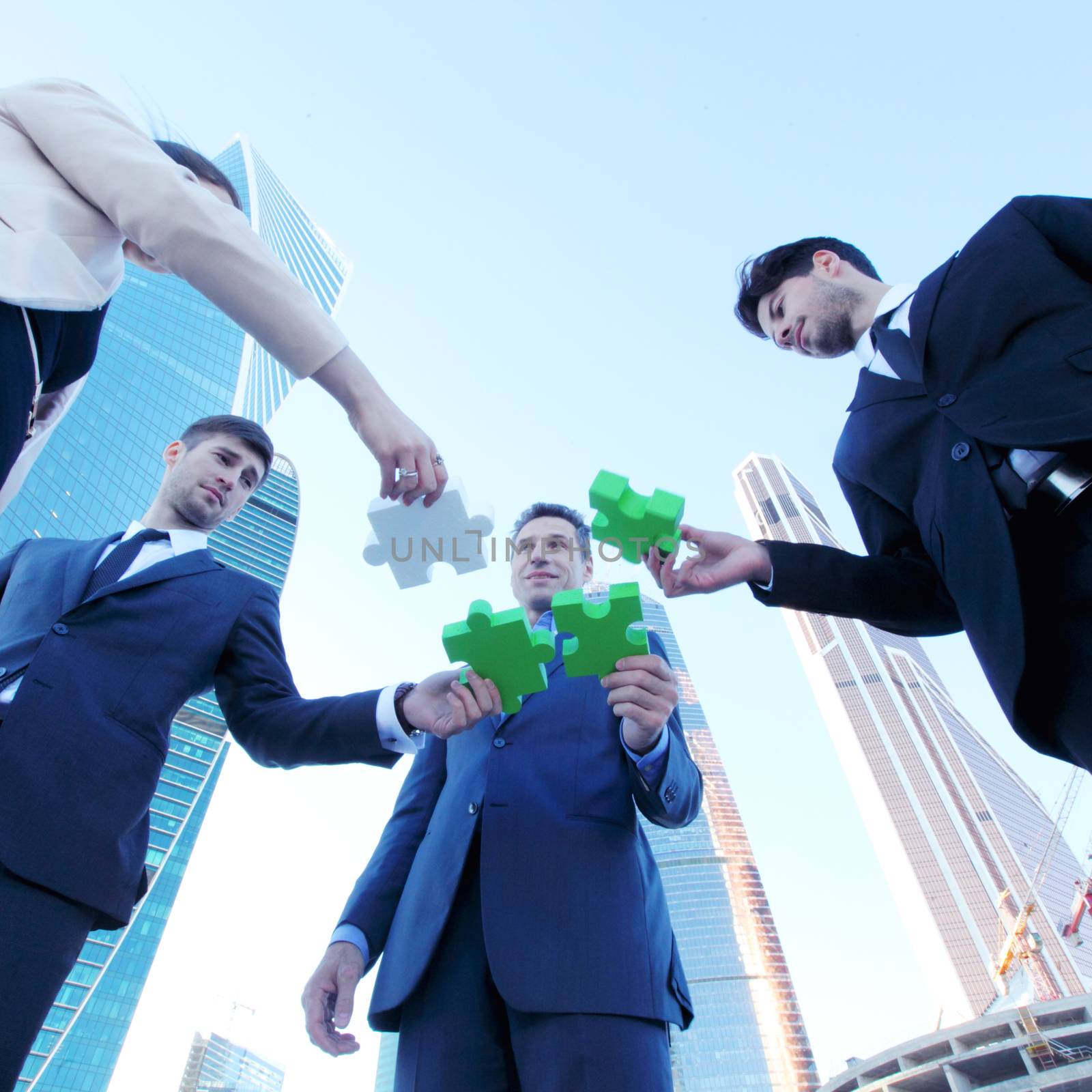 Business people assembling jigsaw puzzle  by ALotOfPeople