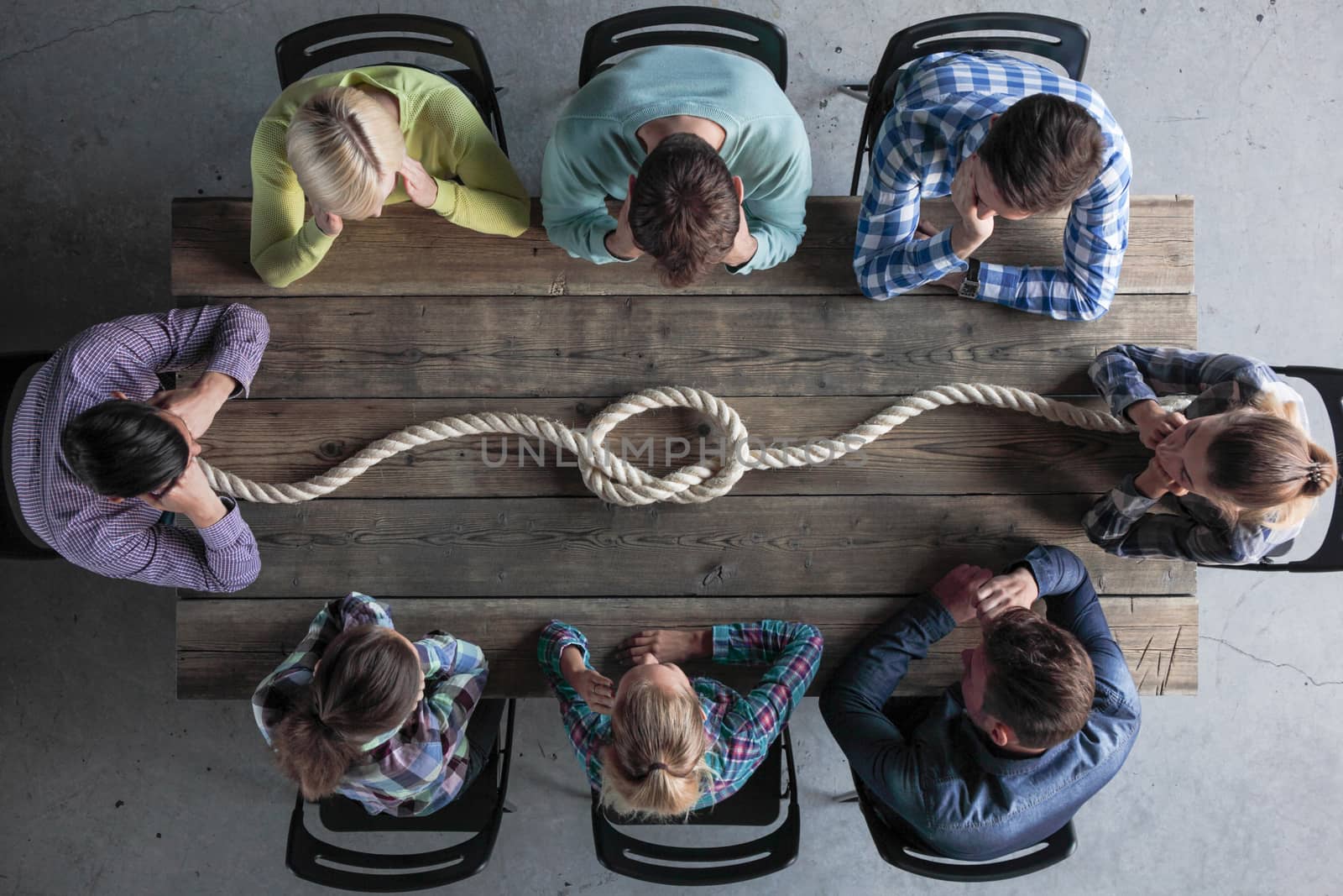 Business teamwork brainstorming planning meeting concept, people in casual clothes sitting around the table with rope node