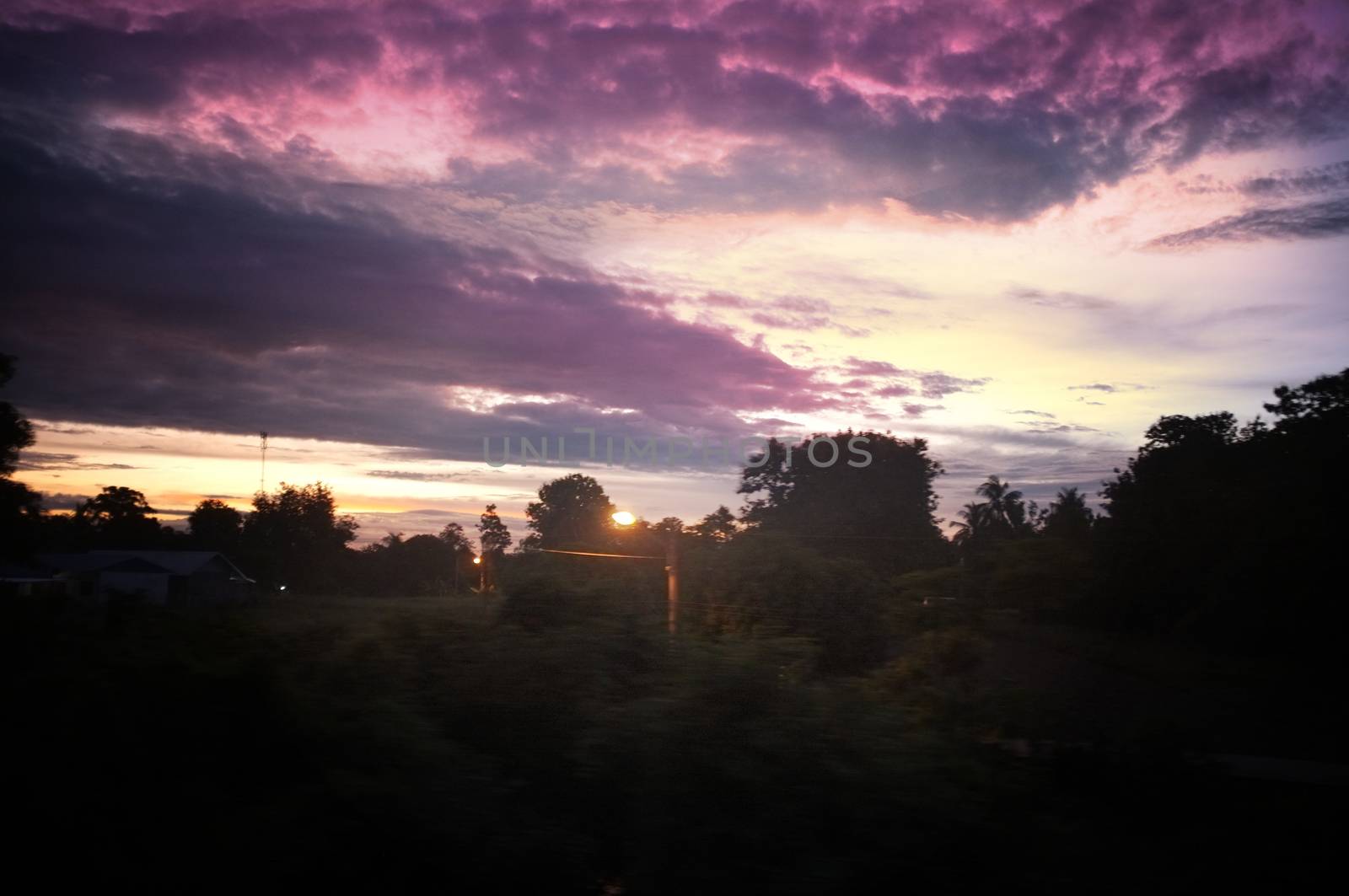 A colorful sunup above a small train station in thailand 