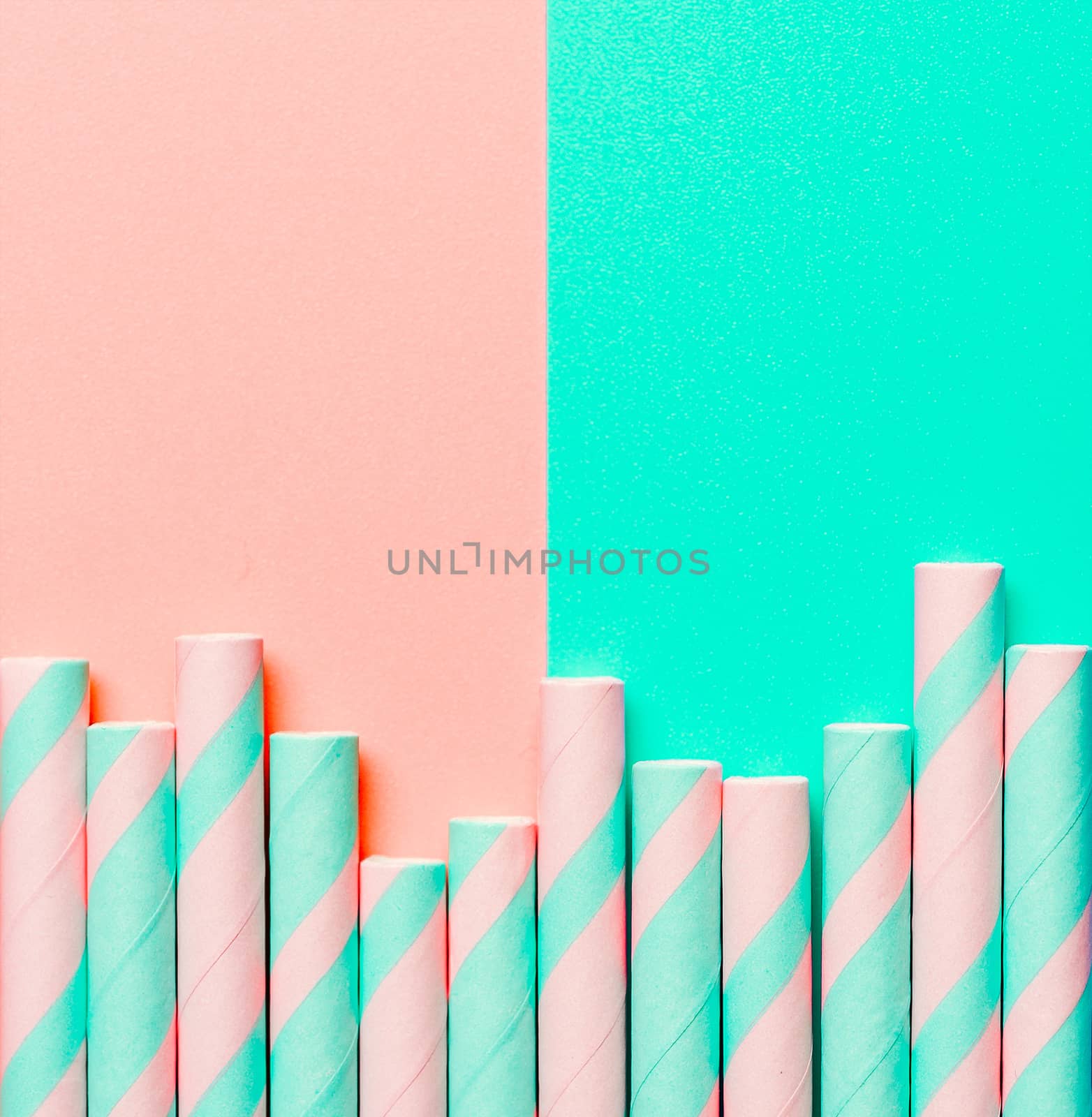 Striped paper straws on pink and blue background by fascinadora