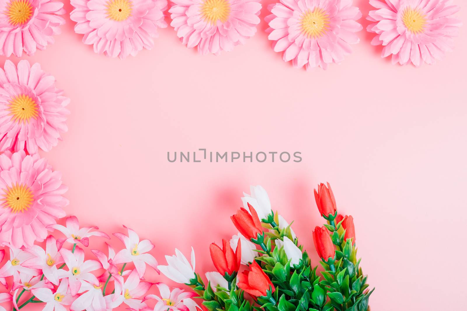 Beautiful flowers top view on pink background with copy space