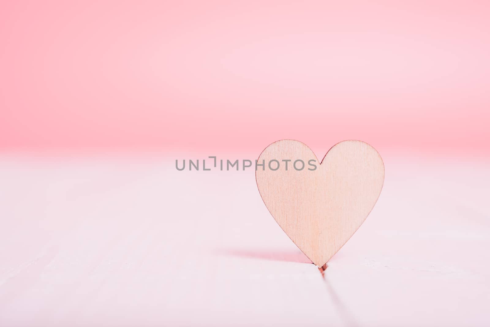 Wood heart on white wooden have pink background by Sorapop