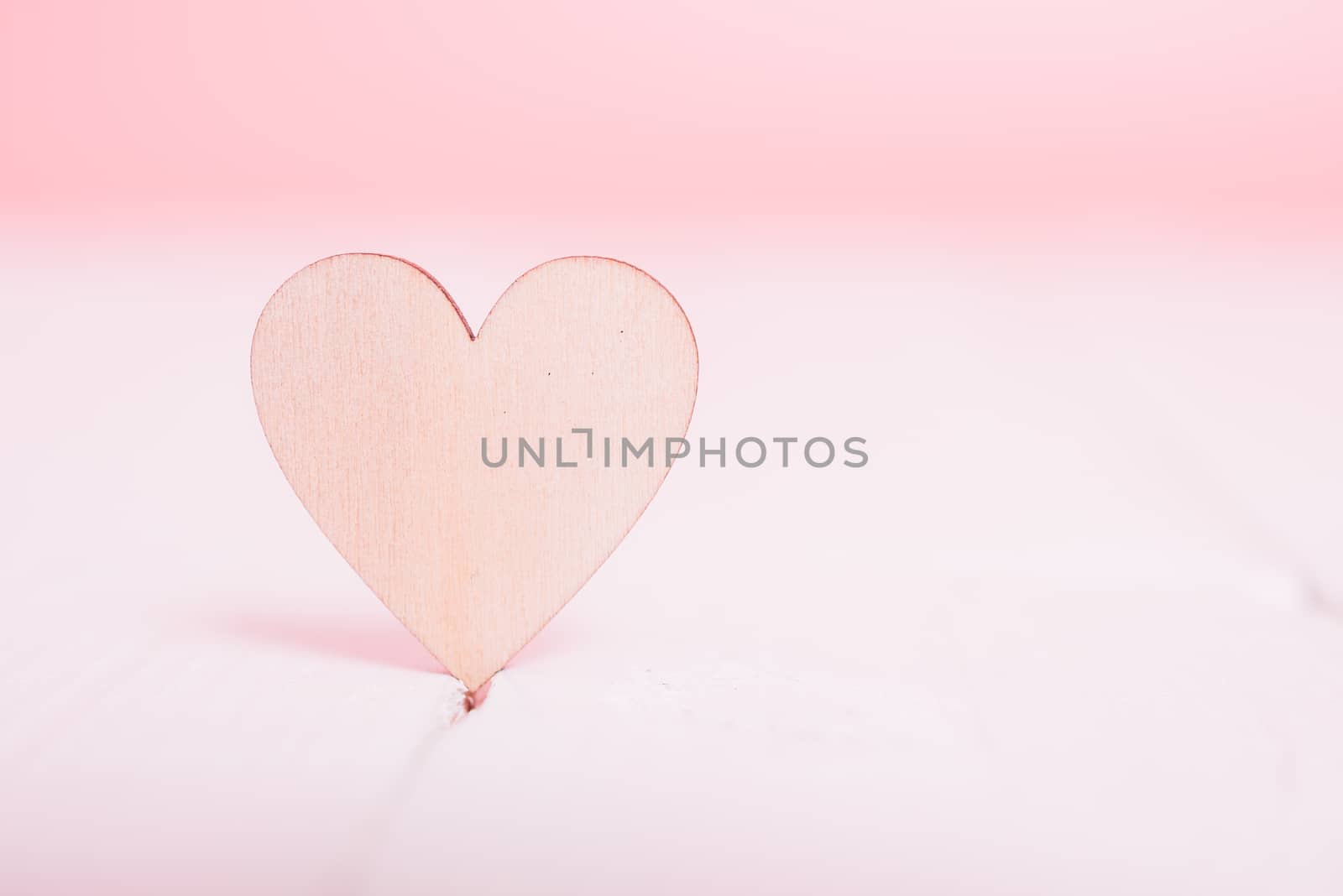 Wood heart on white wooden have pink background by Sorapop