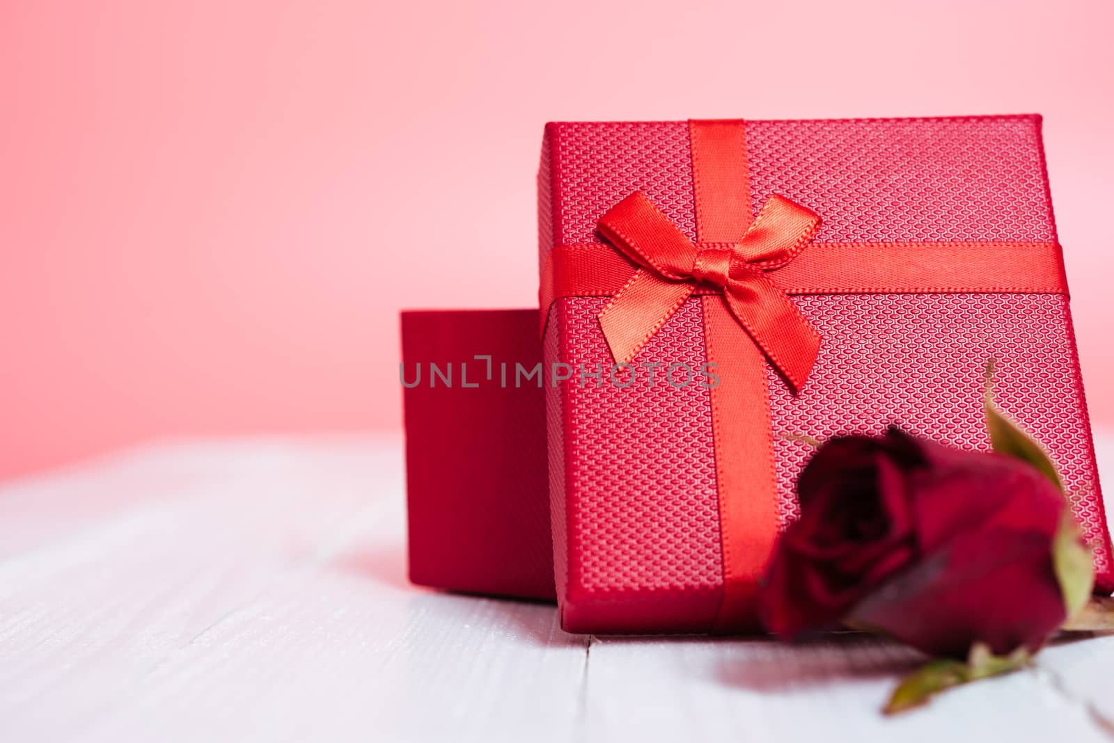 Gift box and flower roses on white wooden background, valentine day concept