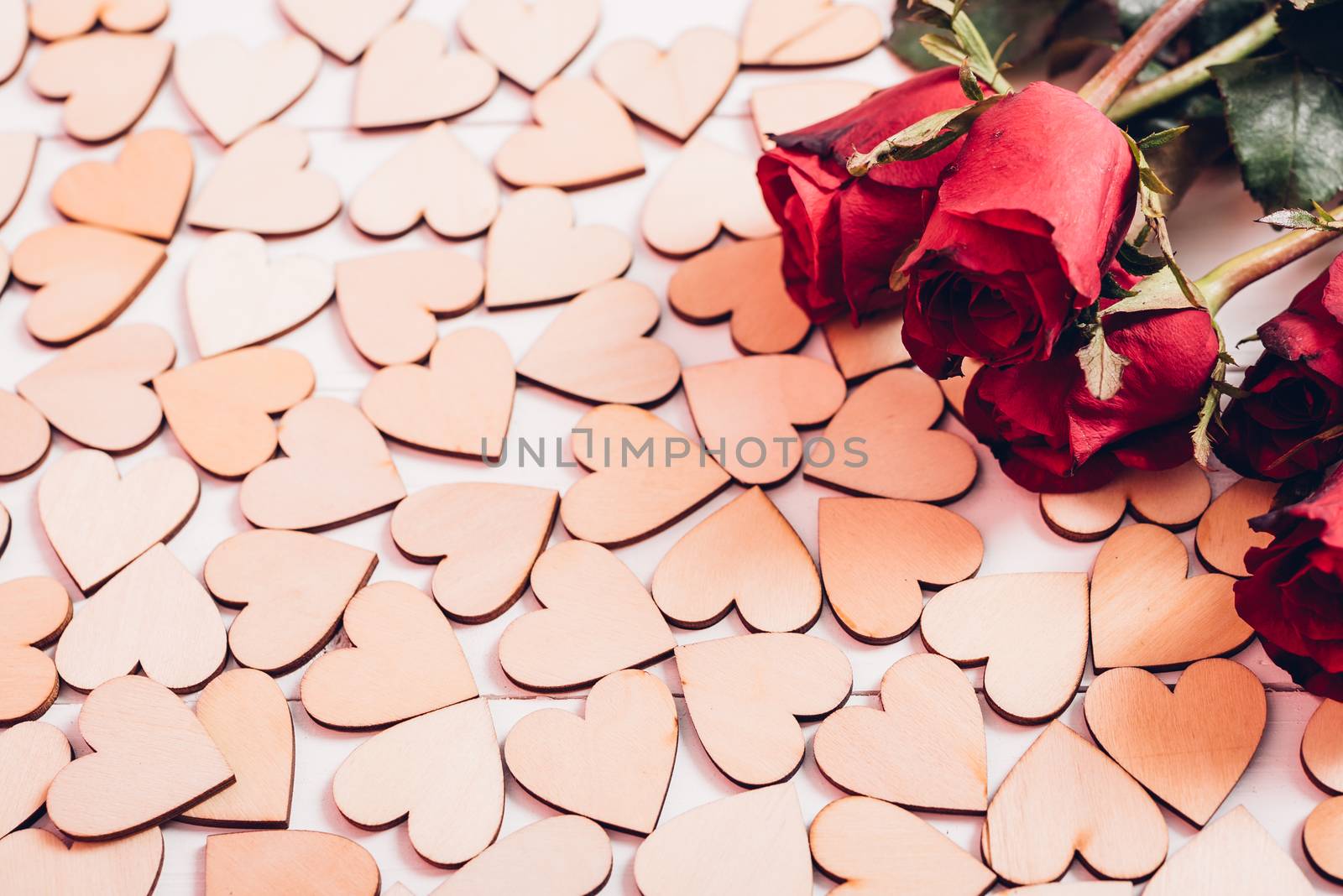 Wood hearts and red roses on white wooden background by Sorapop