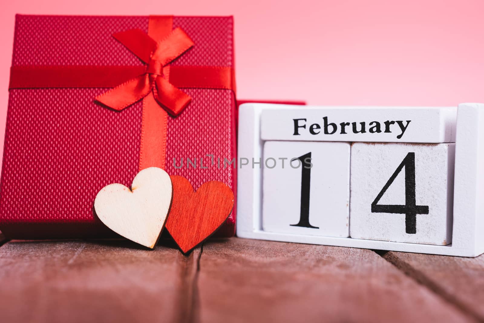 Red wood Hearts and gift box on wooden and pink background, 14 February, valentine day concept