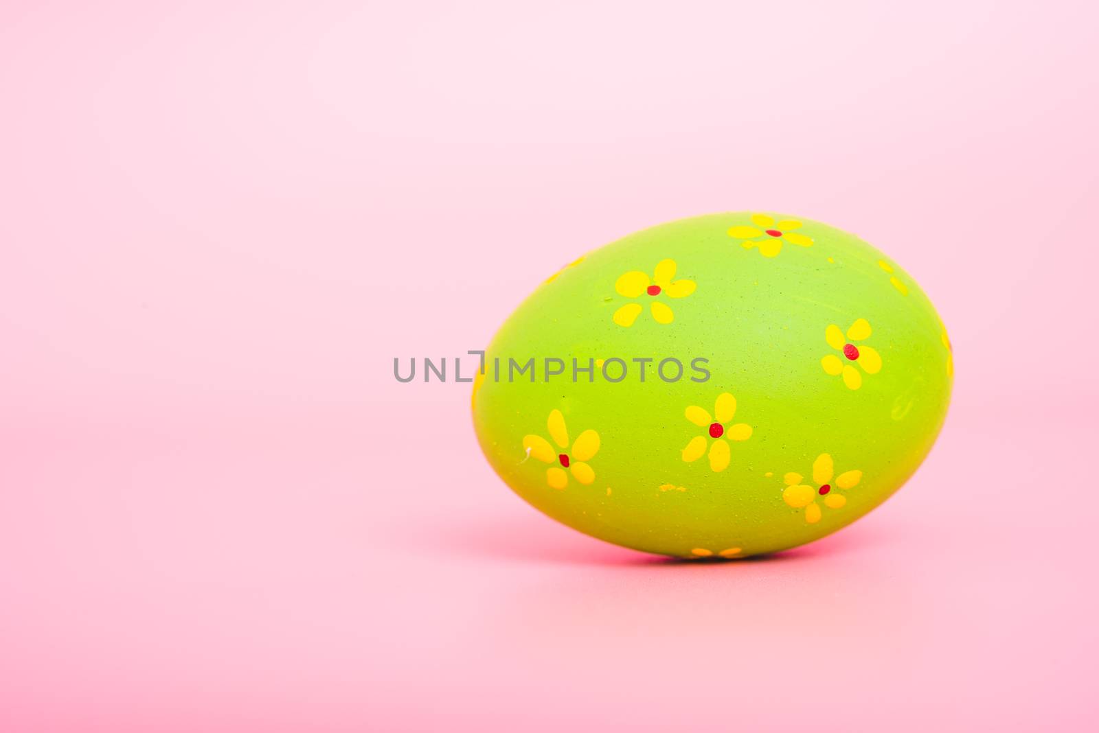 Beautiful Easter green egg color on pink background, Easter day concept