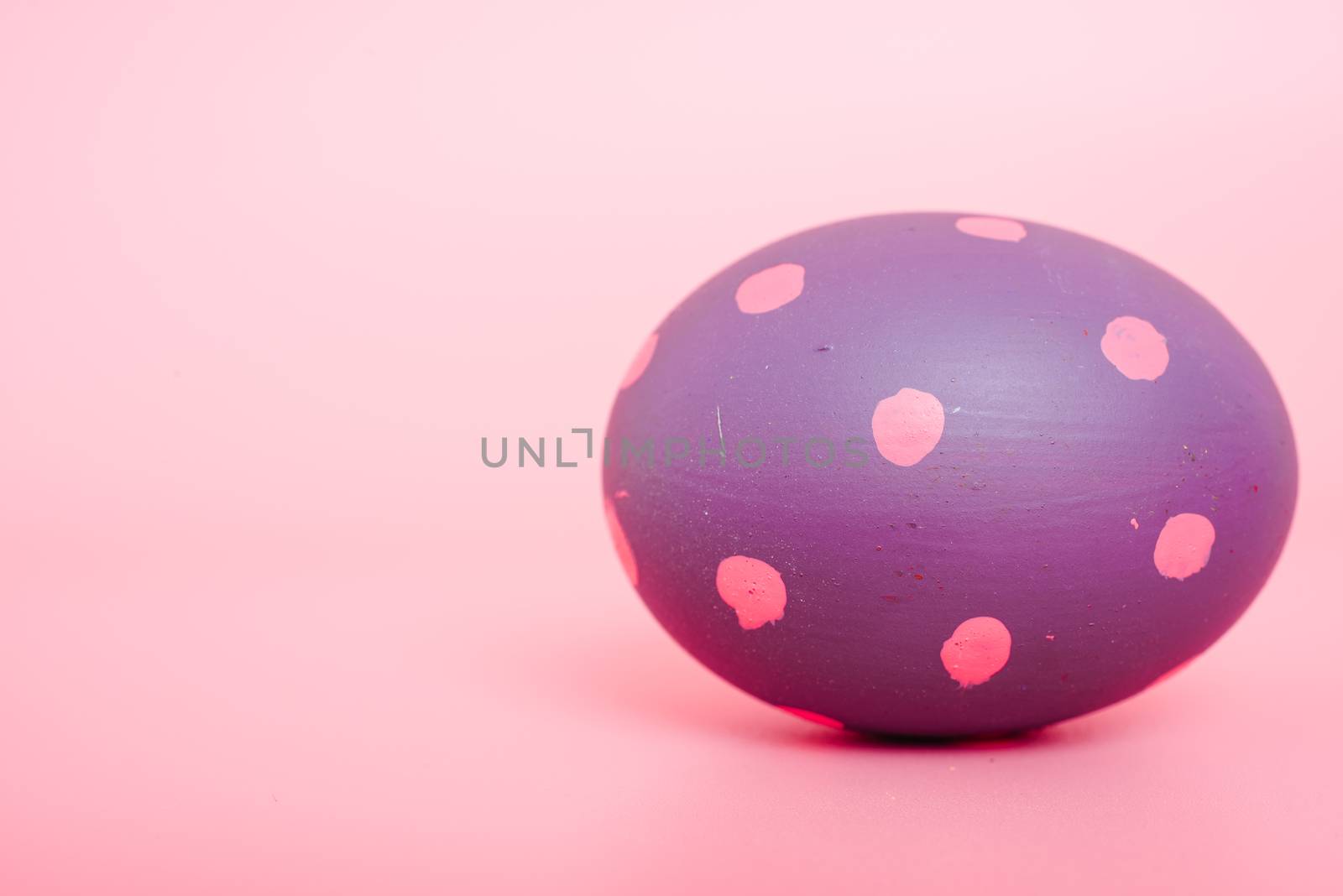 Beautiful Easter purple egg color on pink background, Easter day concept