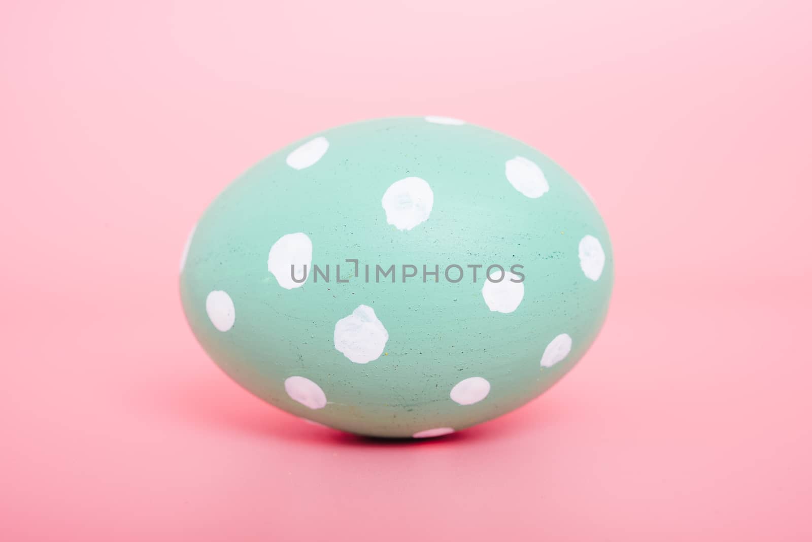 Beautiful Easter Green egg color on pink background, Easter day concept