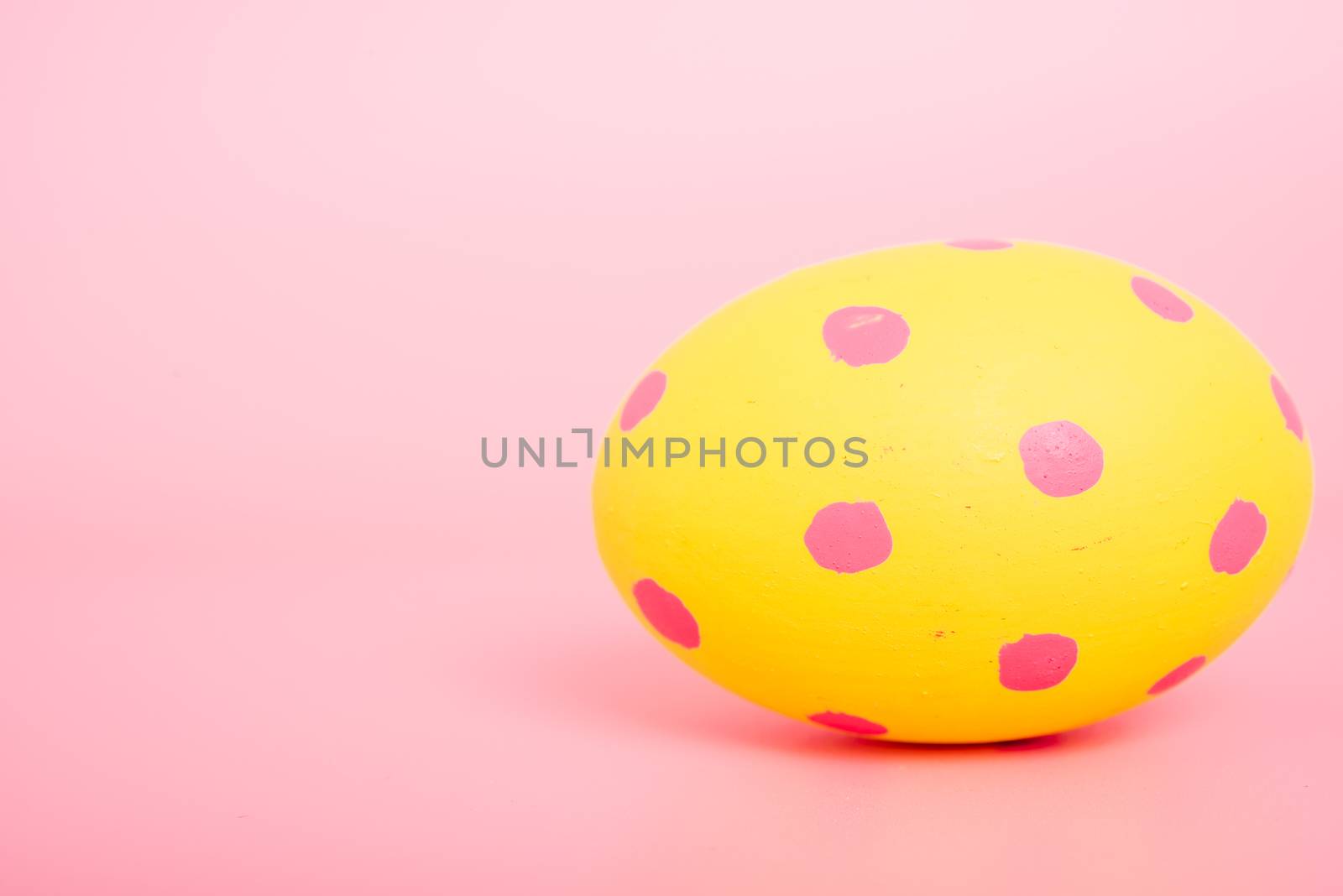 Beautiful Easter Yellow egg color on pink background, Easter day concept