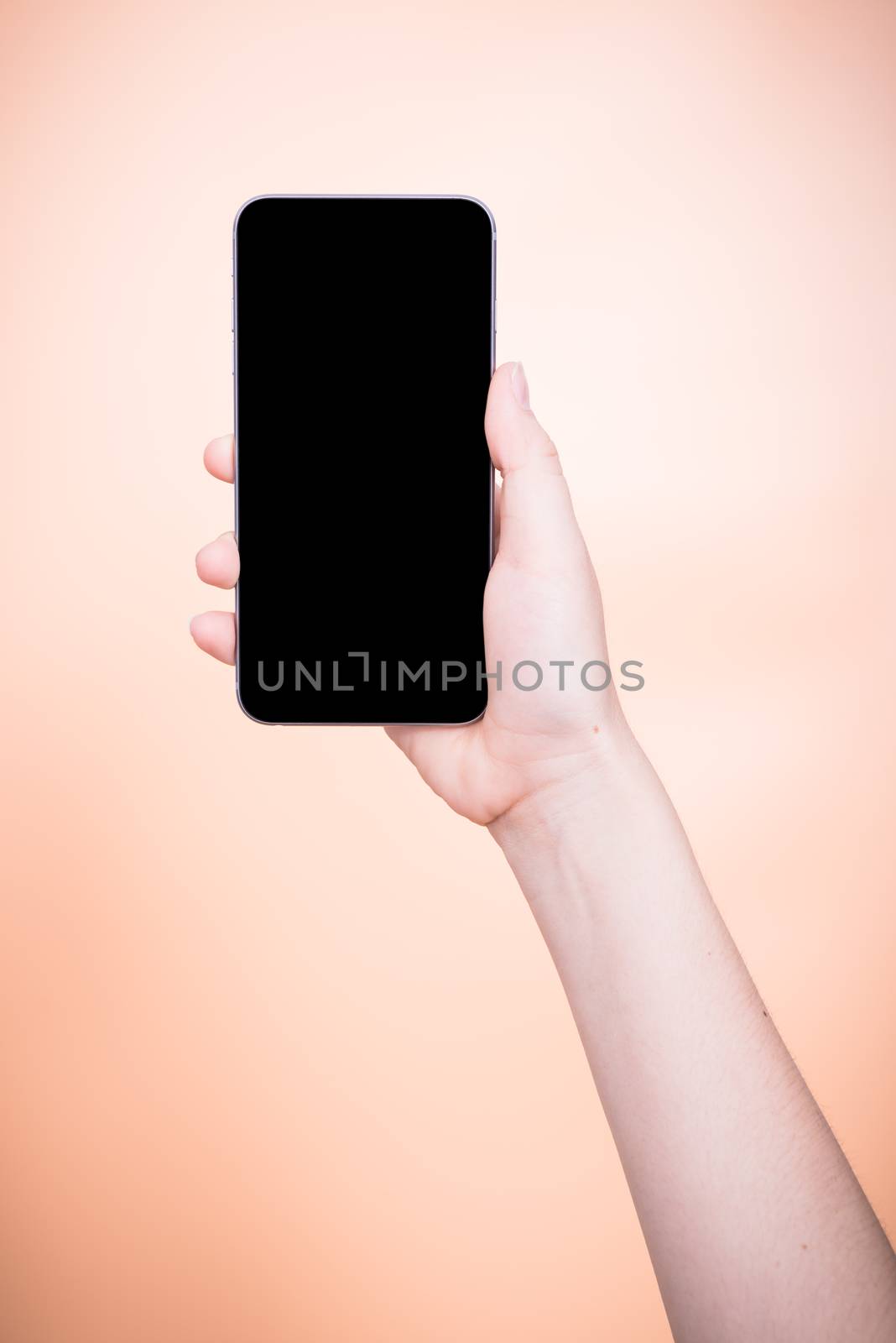 Female holding mobile smartphone plus blank screen on orange color background