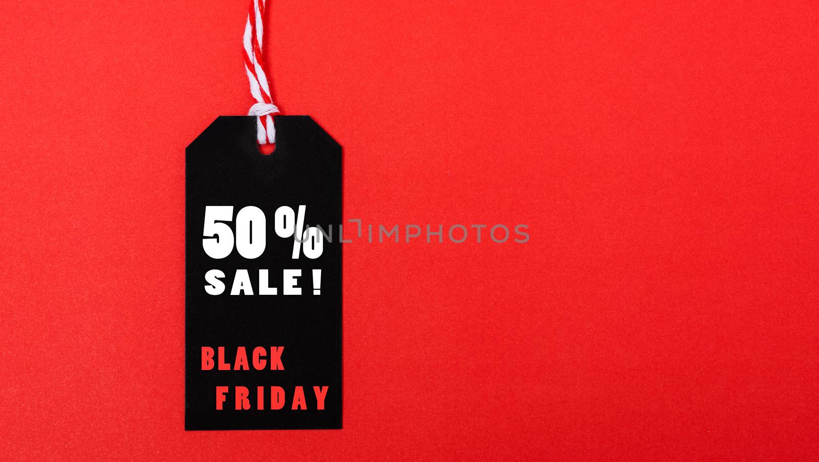 Online shopping, Promotion Black Friday Sale 50% text on black tag on red background.