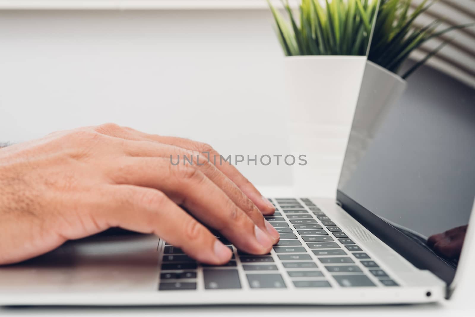 Hands of male businessmen Using keyboard on laptop by Sorapop