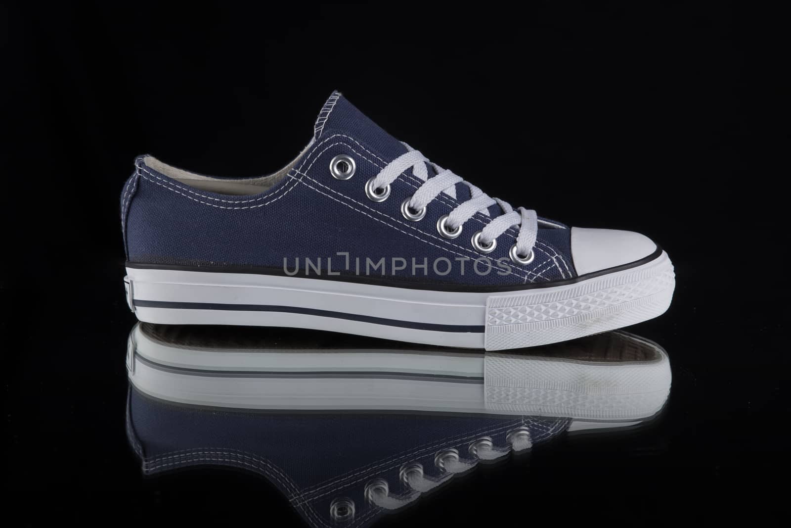 Blue and white sneaker on black background, isolated product.