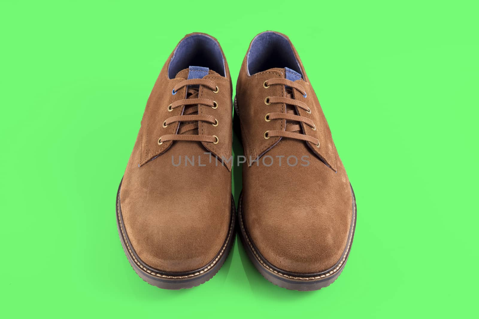 Pair of brown shoes on green background, isolated product. by GeorgeVieiraSilva