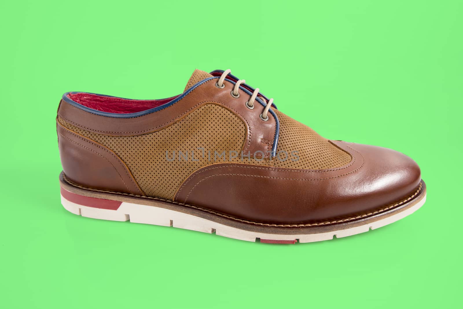 Male brown shoes on green background, isolated product.