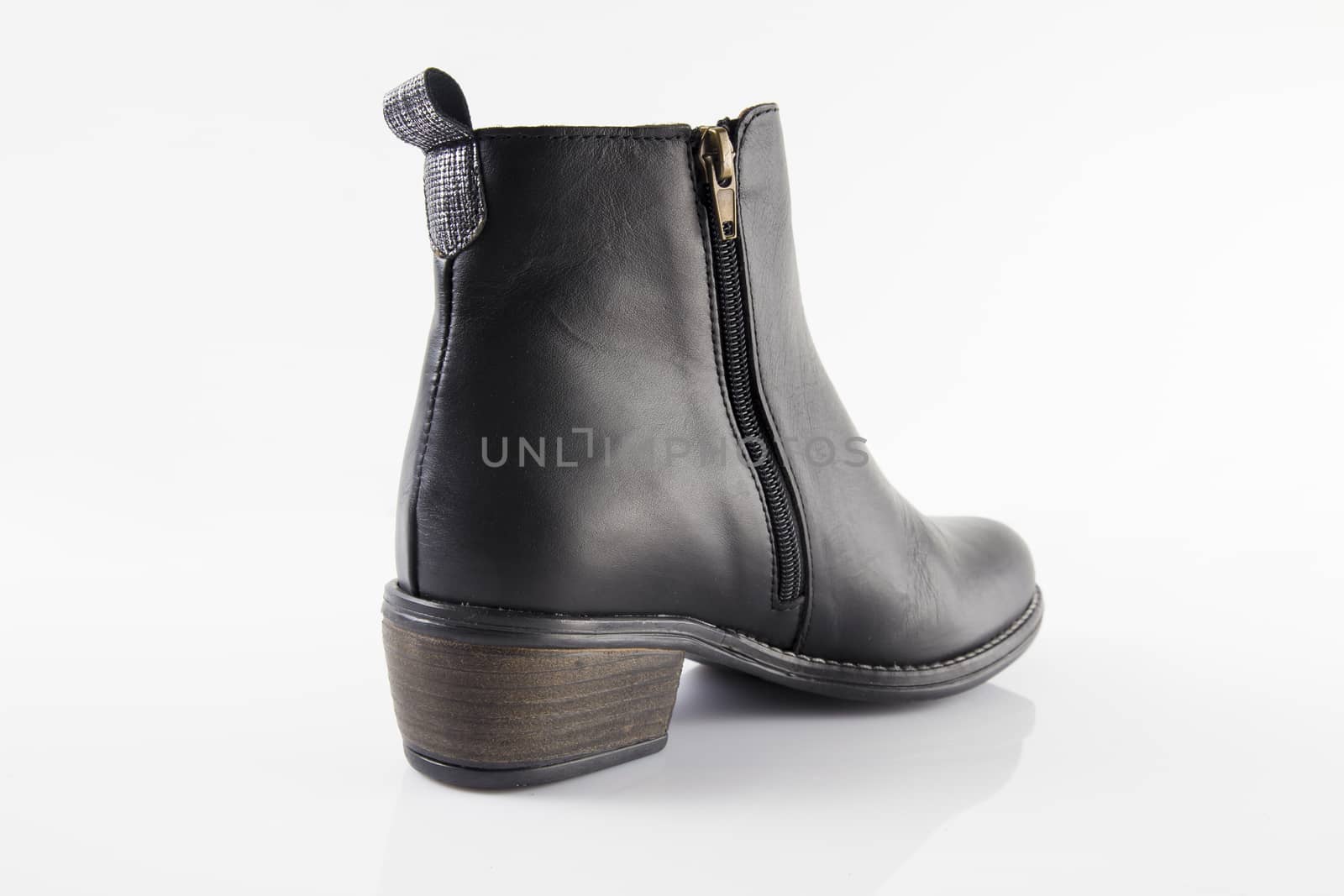 Female black leather boot on white background, isolated product, top view.