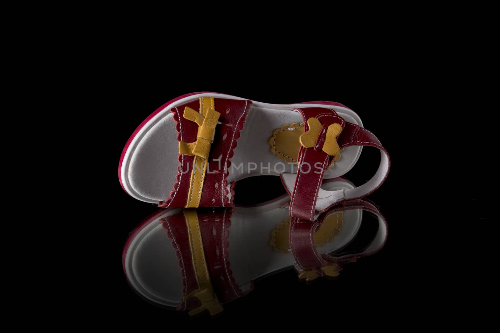 Red leather sandal on black background, isolated product. by GeorgeVieiraSilva