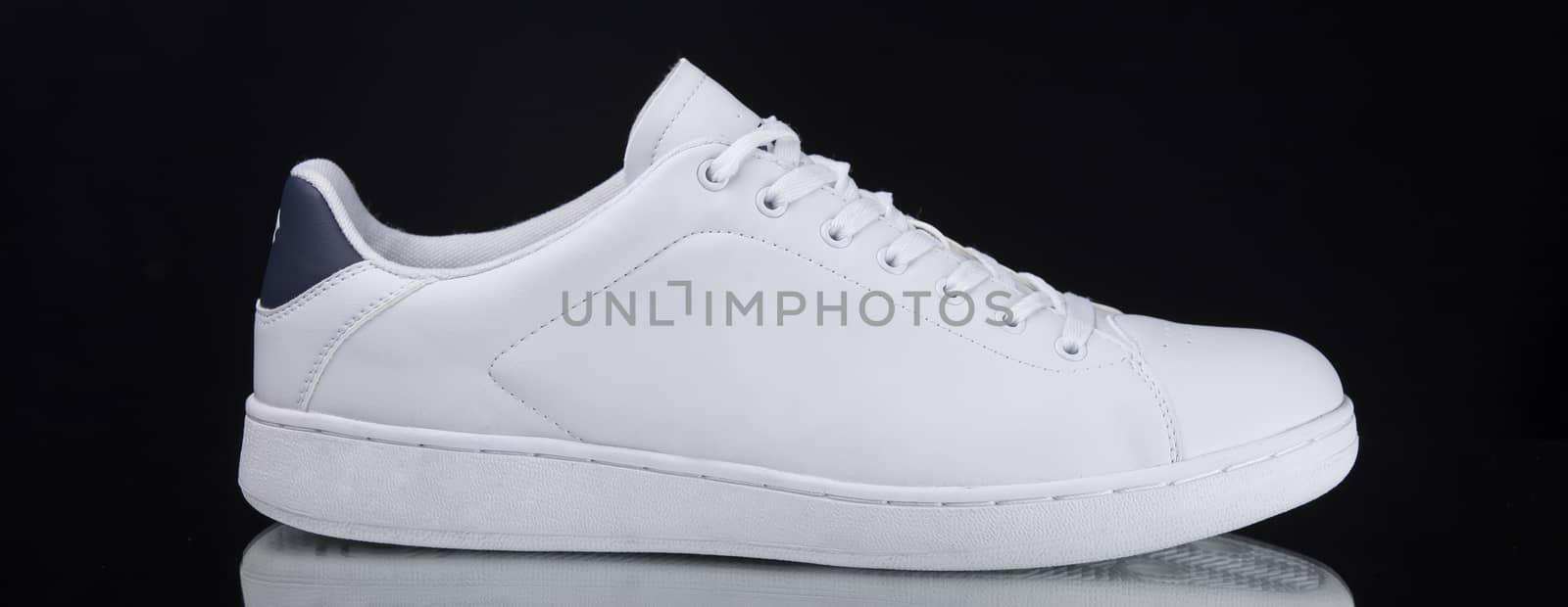 Male white sneaker on black background, isolated product. by GeorgeVieiraSilva