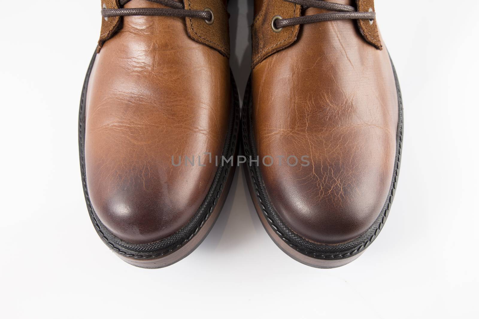 Pair of brown leather boots on white background, isolated product, top view.