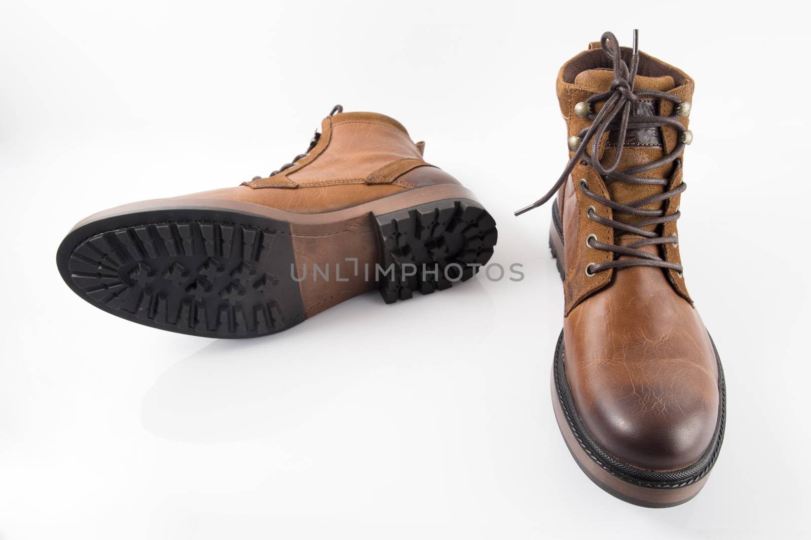 Pair of brown leather boots on white background, isolated product, top view.