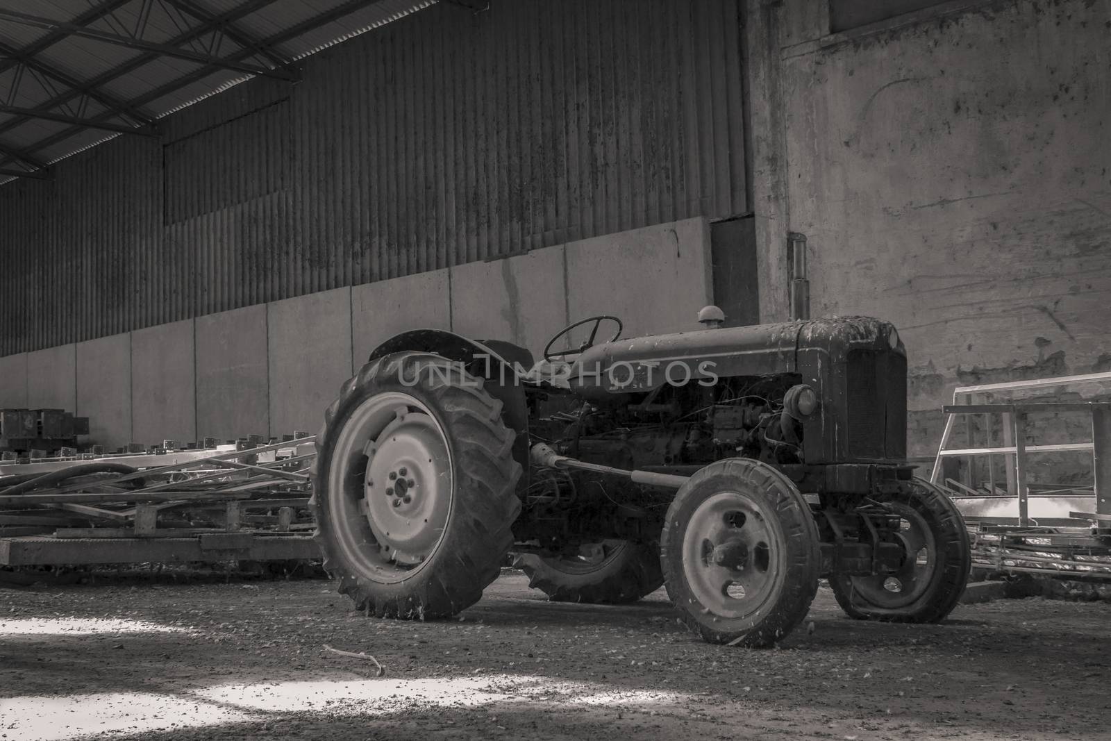Old abandoned tractor in a shed. Full of dust and dirt left to itself was old and outdated.