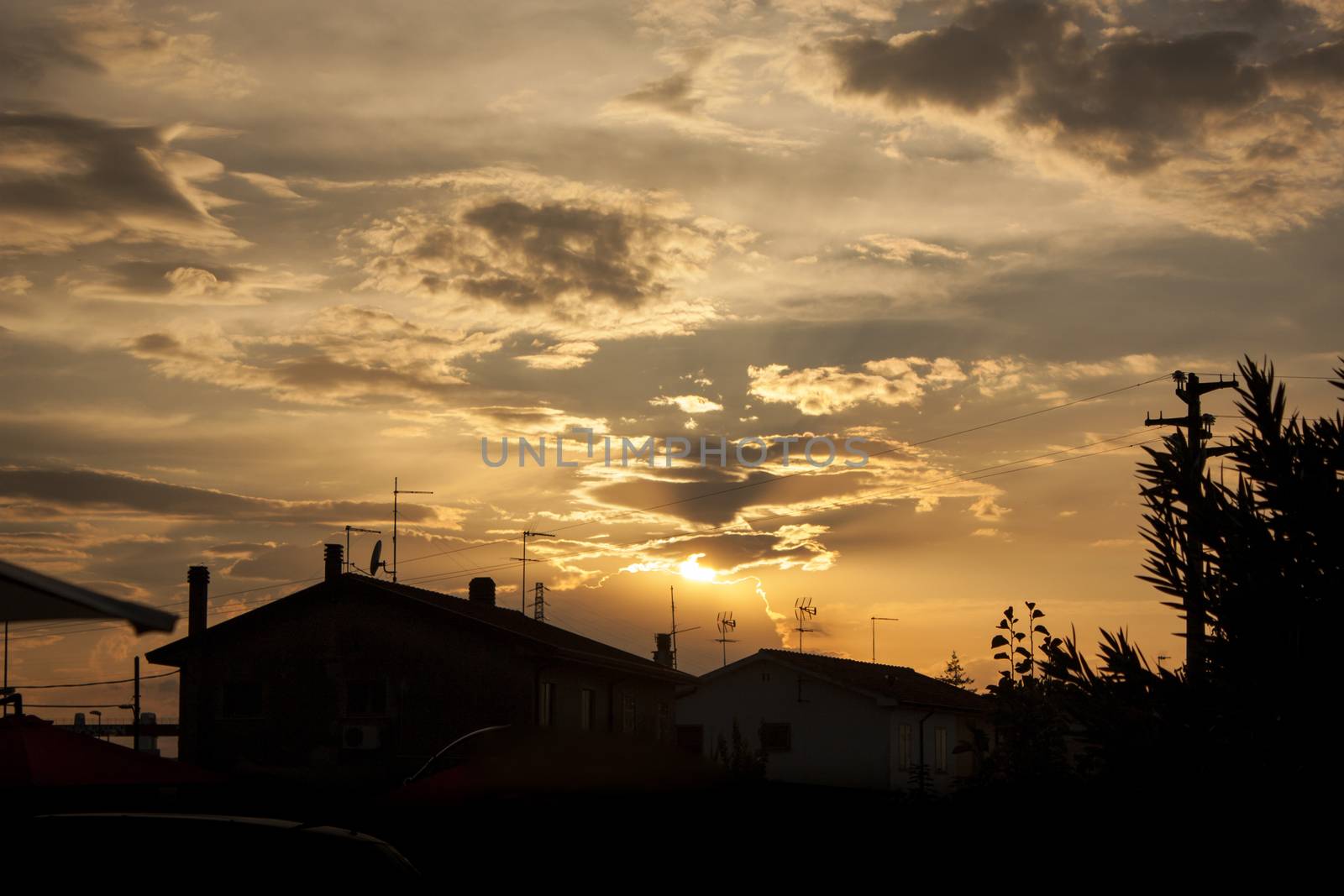 Sunset in a small Italian village, and highlight the silhouette of houses and elements that make up the landscape as a whole.