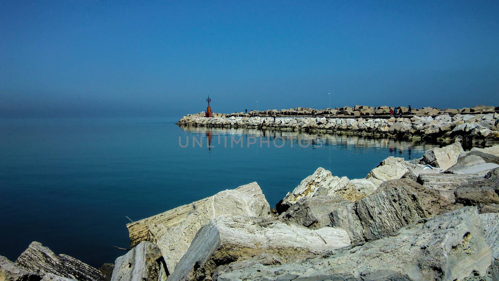 Heavenly view of the pier of the port of Giulianova in Abruzzo Italy. A mystical landscape in which the orrizzontre line between sky and sea merge into a unique spectacle.