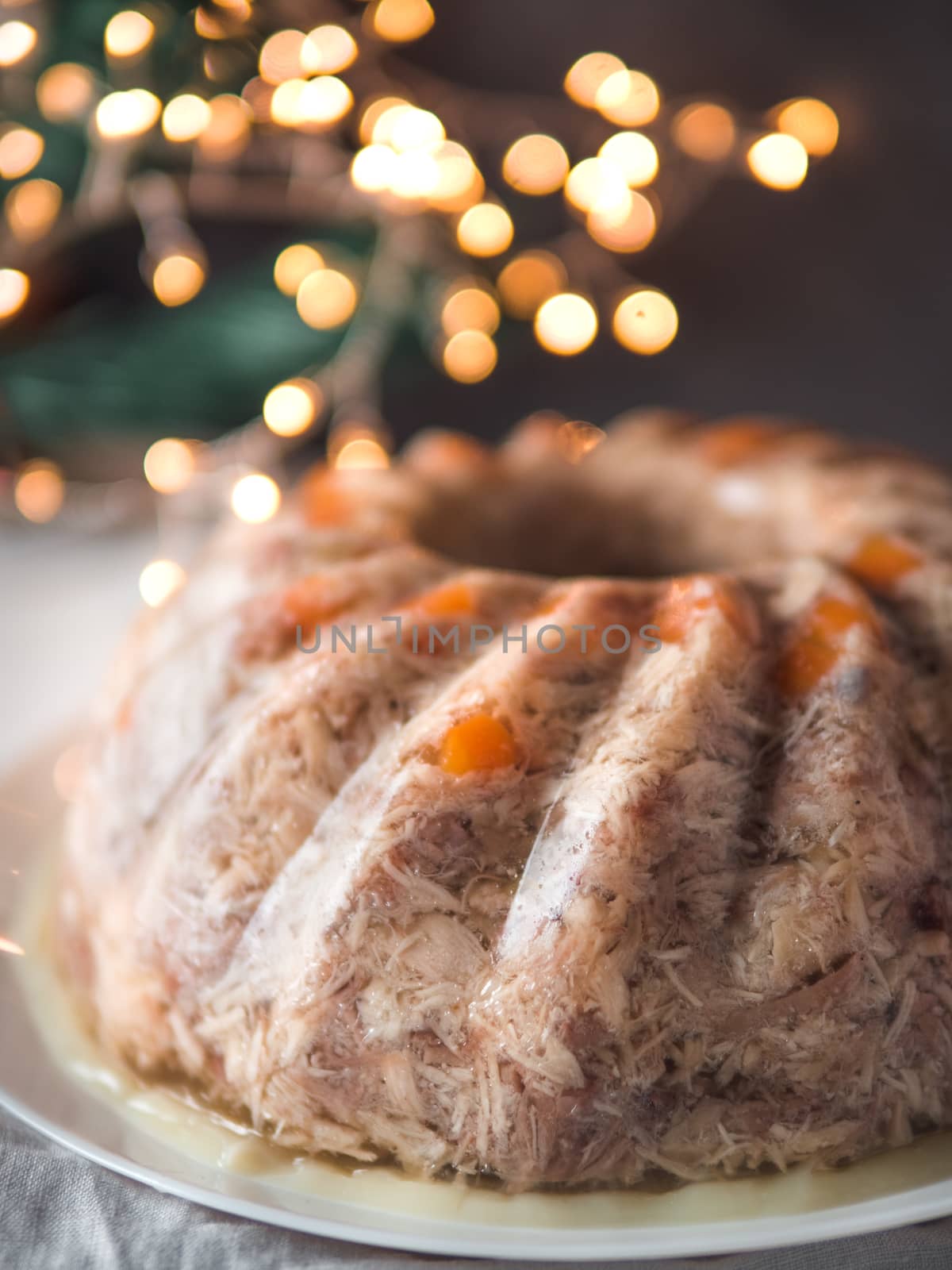 Homemade delicious jelly meat on festive Christmas table. Close up view of perfect jellied meat, aspic, galantine with carrot. Copy space for text. Vertical.