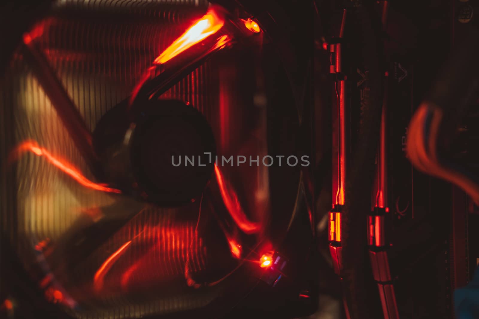 Computer fan and electronic components in red light from inside the tower. by mikelju