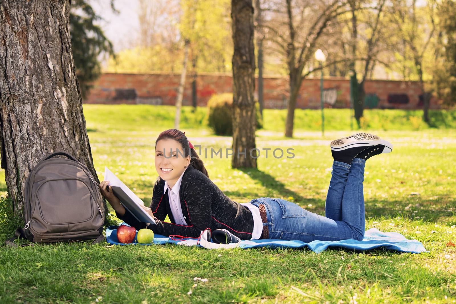 Girl in a park reading a book by Mendelex
